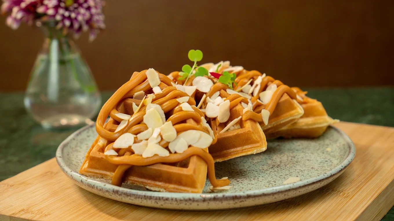 Waffle coberto com doce de leite e amêndoas laminadas